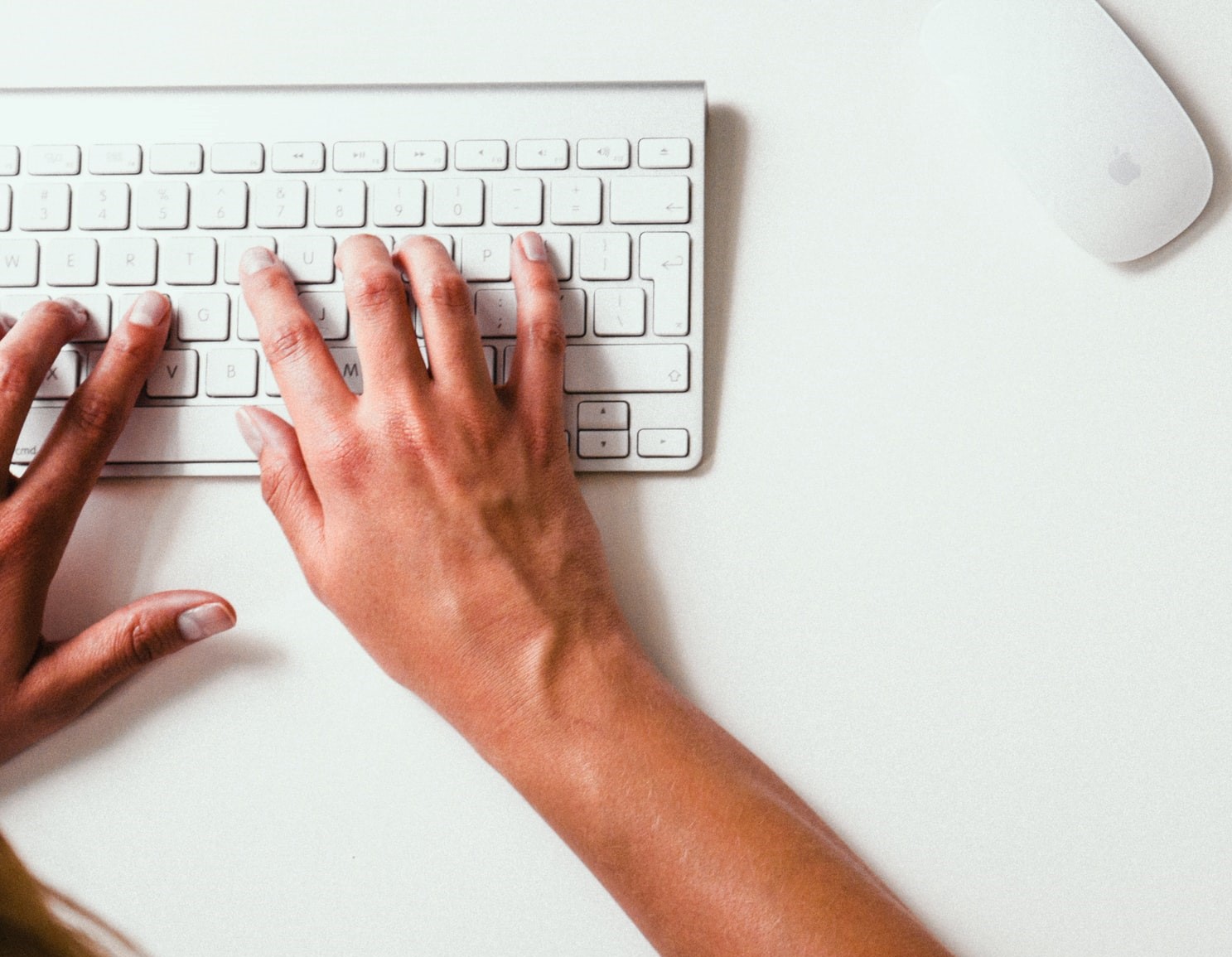 hands typing on computer keyboard