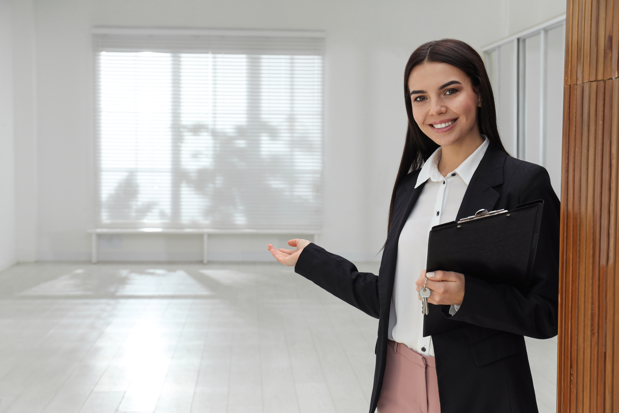 A leasing agent showing an empty room in an apartment